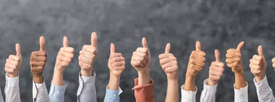 Image shows a bunch of people giving a thumbs up