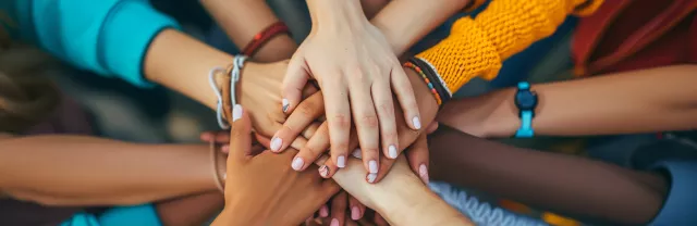 Shows a bunch of hands stacked together