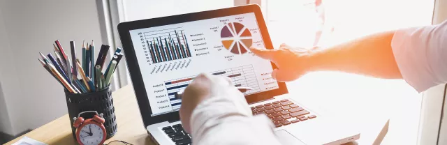 Two people looking at data on a computer